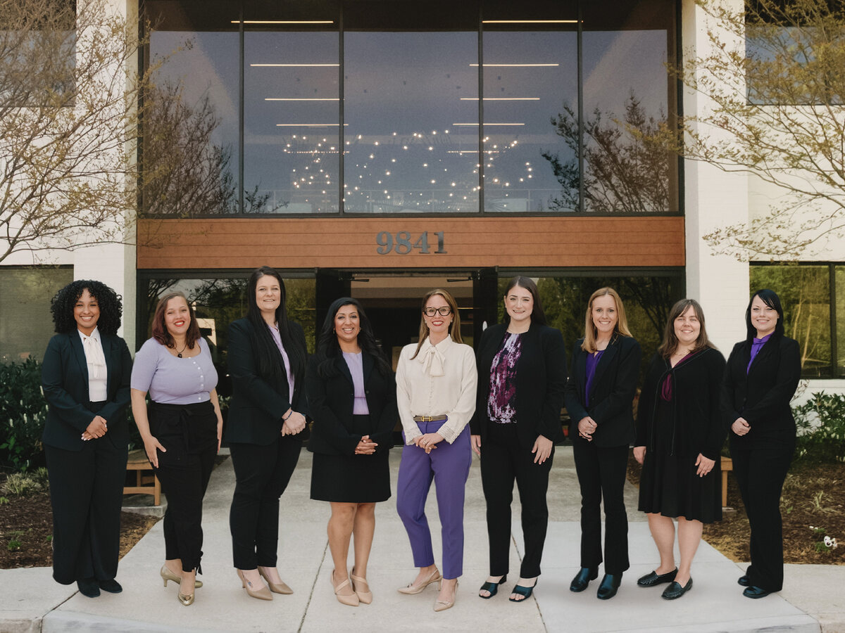 The attorneys and staff of Leffler, Bayoumi & Oliver, LLC outside their office at 9841 Broken Land Parkway in Columbia, Maryland